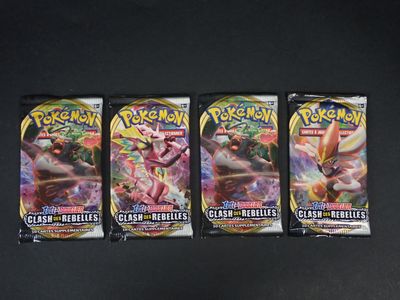 trois paquets de cartes du jeu de cartes Pokémon posés sur une surface noire