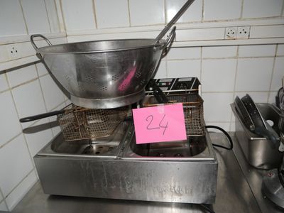 a frying pan on a stove with a pink sign on it
