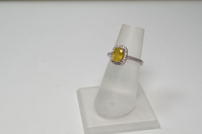 Gros plan sur une bague ornée d'une pierre jaune
