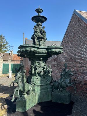 a statue of a fountain in front of a brick building