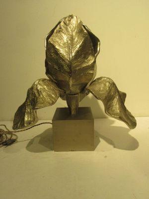 a metal sculpture of a flower on a wooden base