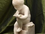 a small statue of a baby sitting on a potty