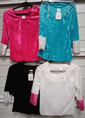 three different colored shirts hanging on a rack in a store