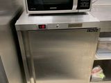 un micro-ondes argenté posé sur un plan de travail en inox