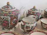 plusieurs assiettes et tasses et une théière sur la table