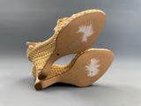 un gros plan sur une paire de chaussures pour femme posée sur une surface grise