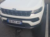 une jeep blanche garée sur un parking, dans un parking