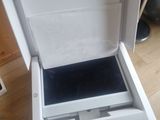 a open white box with a black lid on a wooden floor