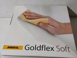 Quelqu'un nettoie une boîte de « Goldflex Soft » avec un chiffon.