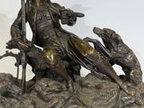 statue of a man sitting on a rock with a dog and a cat