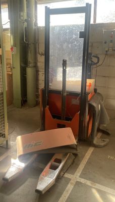 a forklift in a garage with a box on the floor