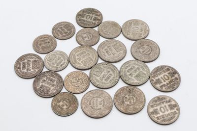 un gros plan sur un tas de vieilles pièces de monnaie posées sur une surface blanche