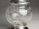 a glass jar with a silver lid on a table