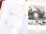 un livre ouvert sur lequel figure une carte, avec une paire de ciseaux posée dessus