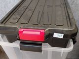 a plastic box with a red lid sitting on the floor