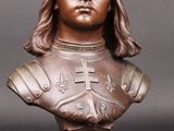 un gros plan sur un buste en bronze représentant un homme aux cheveux longs