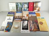 Plusieurs livres sont empilés sur une table devant un fond blanc.