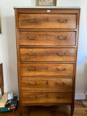 a wooden chest of drawers in the corner of a room