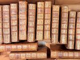de nombreux vieux livres dans un carton posé par terre