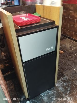 a small refrigerator sitting in the middle of a kitchen