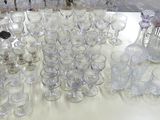 une table sur laquelle se trouvent de nombreux verres et un pichet