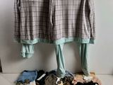 two shirts hanging on a clothes rack next to a purse