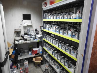 many cans of paint on the shelves in the room
