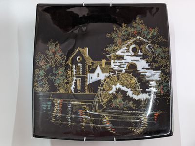 a black plate with a picture of a mill on it