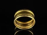 a close up of a gold ring on a black surface