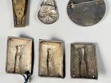 some silver metal items are laying out on a white surface