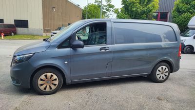 La petite camionnette est garée sur le parking, à côté d'autres voitures.