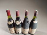 four bottles of wine are lined up on a table
