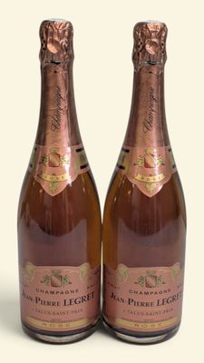 deux bouteilles de champagne posées l'une à côté de l'autre sur une surface blanche