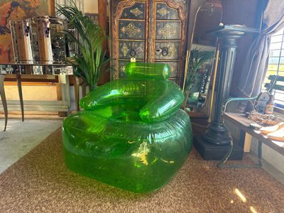 a green chair that is sitting in the middle of a living room