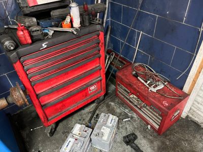 une boîte à outils rouge sur laquelle sont posés des outils