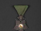 an image of a medal with a green ribbon on a black background