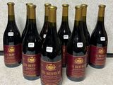 six bouteilles de vin rouge sont alignées sur un comptoir
