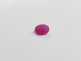 a pink oval stone on a white surface