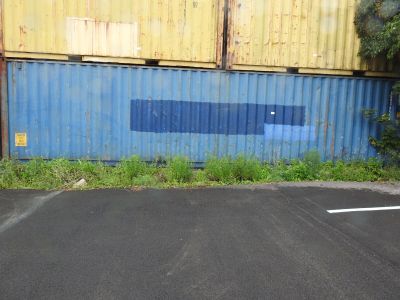 un parking avec un mur bleu et un bâtiment jaune