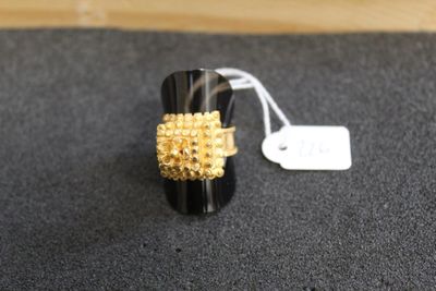 gros plan d'une bague sur une surface noire avec une étiquette de prix