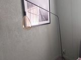 a picture of a living room with a couch and a lamp