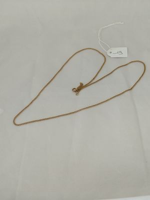 a close up of a gold necklace on a white surface
