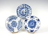 trois assiettes bleues et blanches à motifs sur une surface blanche