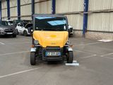 a small yellow car parked in a parking lot