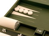 un plateau de backgammon vert avec des pions blancs et un rouleau de tissu