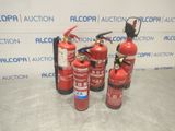 fire extinguisors are lined up on a table in front of a wall