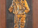a plaque of a soldier holding a flag on a wall