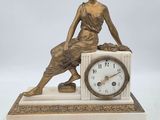 une statue de femme assise au sommet d'une horloge