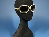 black mannequin head with sunglasses on a blue background
