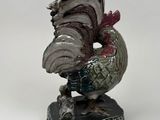 figurine of a rooster on a rock on a white background